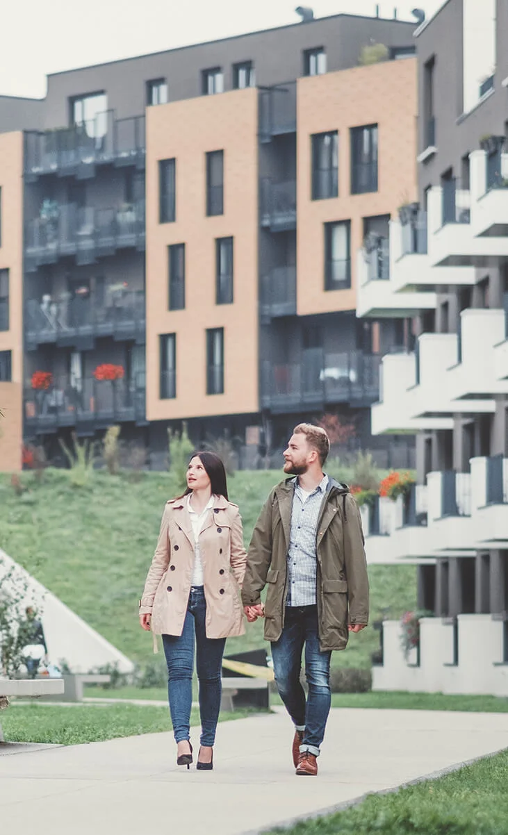 young-couple-walking-buildings apartment fund image - couple walking on an apartment development.